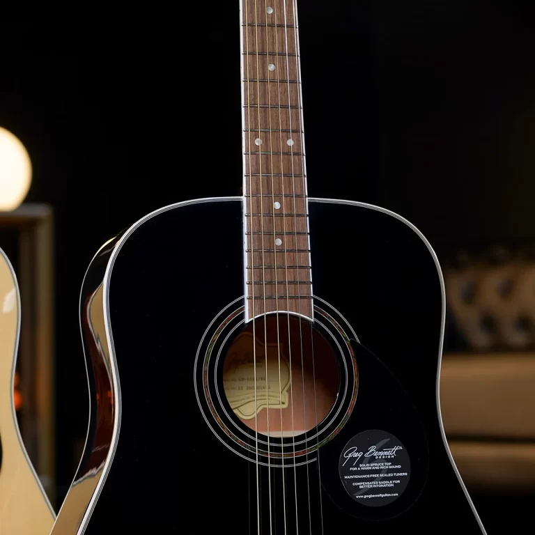 Close-up of a glossy black acoustic guitar from the front, showing the fretboard, strings, and soundhole with a label inside. ขายราคาพิเศษ