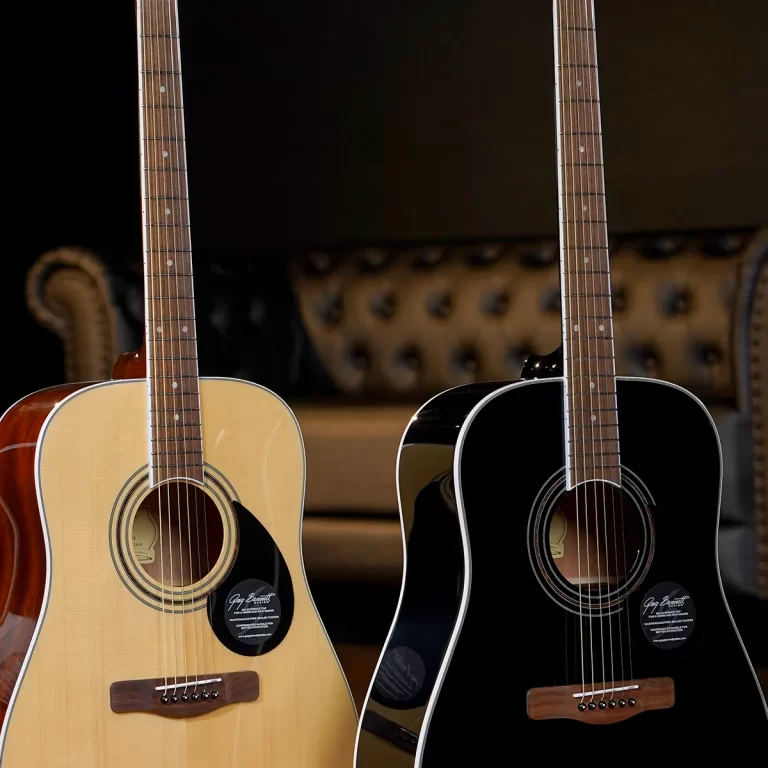 Two acoustic guitars stand side by side in a showroom, one natural wood finish and one black, with a blurred sofa background behind them. ขายราคาพิเศษ