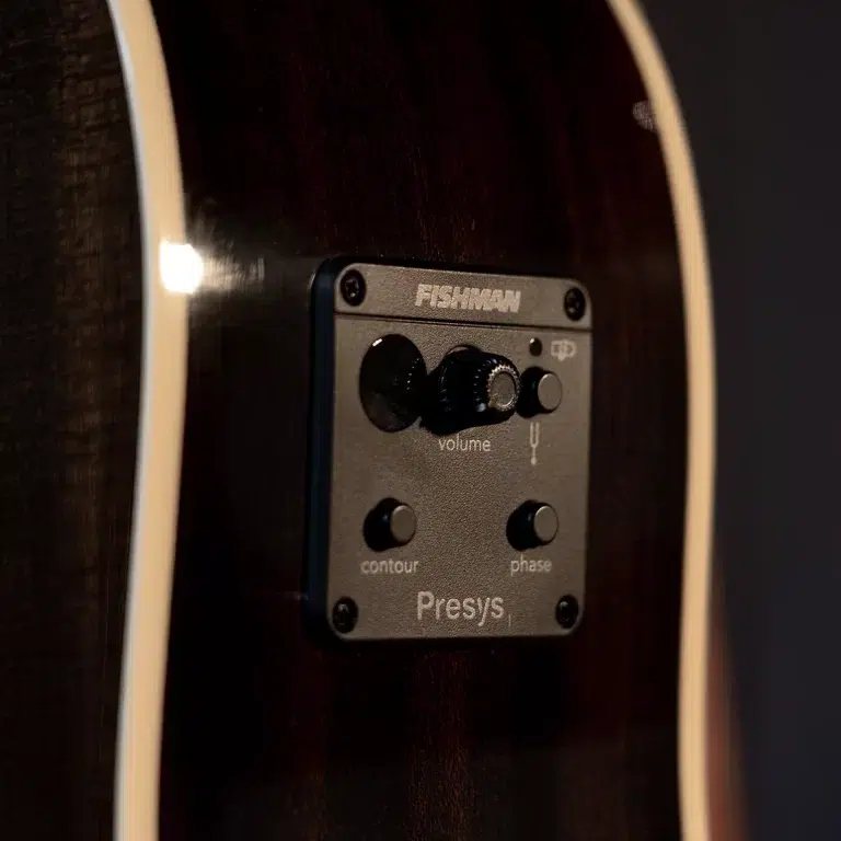 Close-up of a Fishman Presys preamp panel embedded in an acoustic guitar, showing the volume knob and contour/phase controls on the faceplate. ขายราคาพิเศษ
