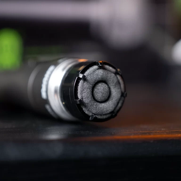 Close-up of a cylindrical device end cap with a foam filter resting on a dark desk surface. ขายราคาพิเศษ