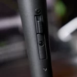 Close-up of a small vertical slider switch on a matte black cylindrical device, with two screws nearby. ขายราคาพิเศษ