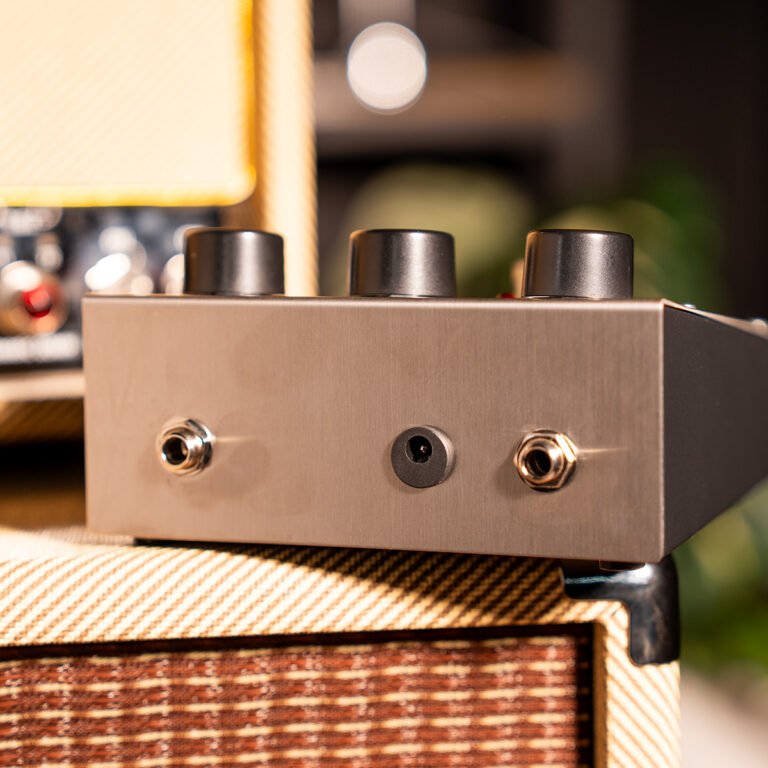 Front panel of a guitar amplifier head with three black knobs and two input jacks on a tweed speaker cabinet. ขายราคาพิเศษ