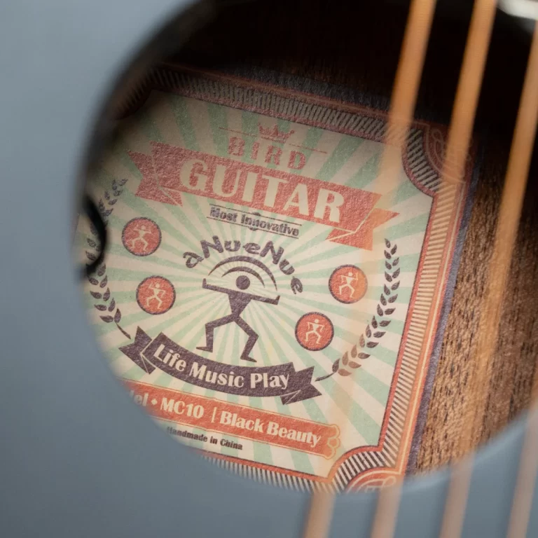 Close-up of a decorative guitar label inside the soundhole showing 'Bird Guitar' and 'Life Music Play' with a stick-figure image. ขายราคาพิเศษ