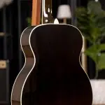Back view of a dark wood acoustic guitar with cream binding in a studio setting ขายราคาพิเศษ