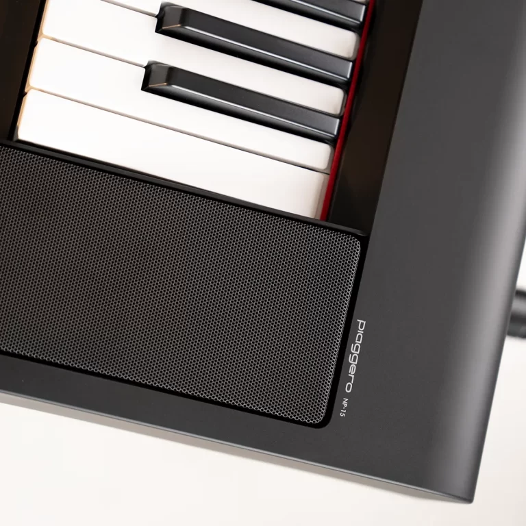 Close-up of a desktop PC front panel with a piano-key motif above a perforated speaker grille. ขายราคาพิเศษ