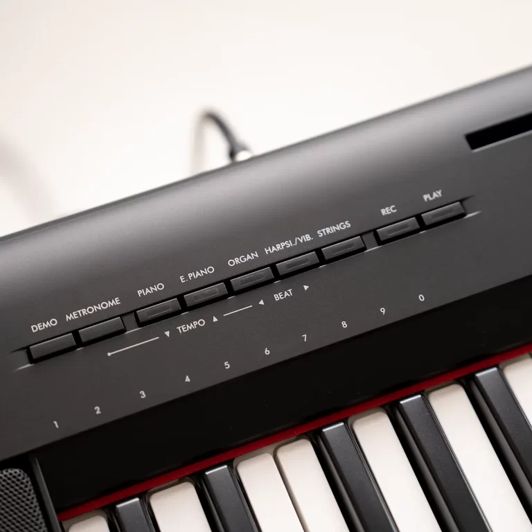 Close-up of an electronic keyboard top panel with instrument buttons (Demo, Metronome, Piano, E. Piano, Organ, Harpsichord/Strings) and playback controls. ขายราคาพิเศษ