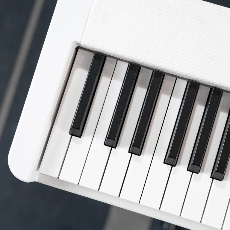 Close-up of a white keyboard showing black and white keys and a white edge with a fabric-covered top edge nearby. ขายราคาพิเศษ