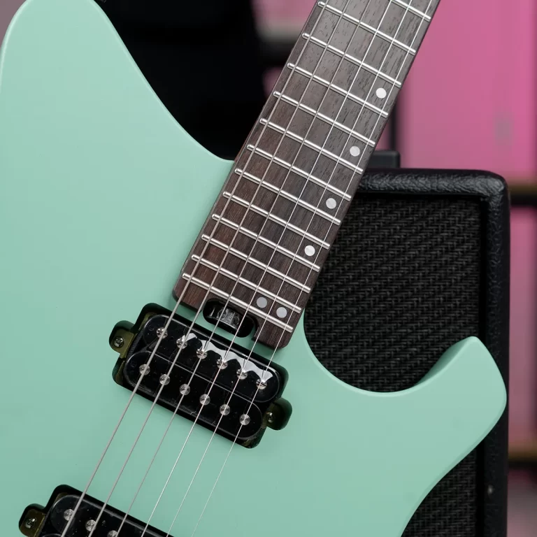 Close-up of a mint-green electric guitar showing the fretboard, strings, and pickups. ขายราคาพิเศษ