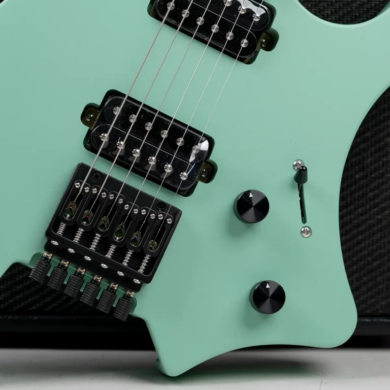 Mint green electric guitar close-up showing two humbucker pickups, the bridge, strings, and control knobs on the body. ขายราคาพิเศษ