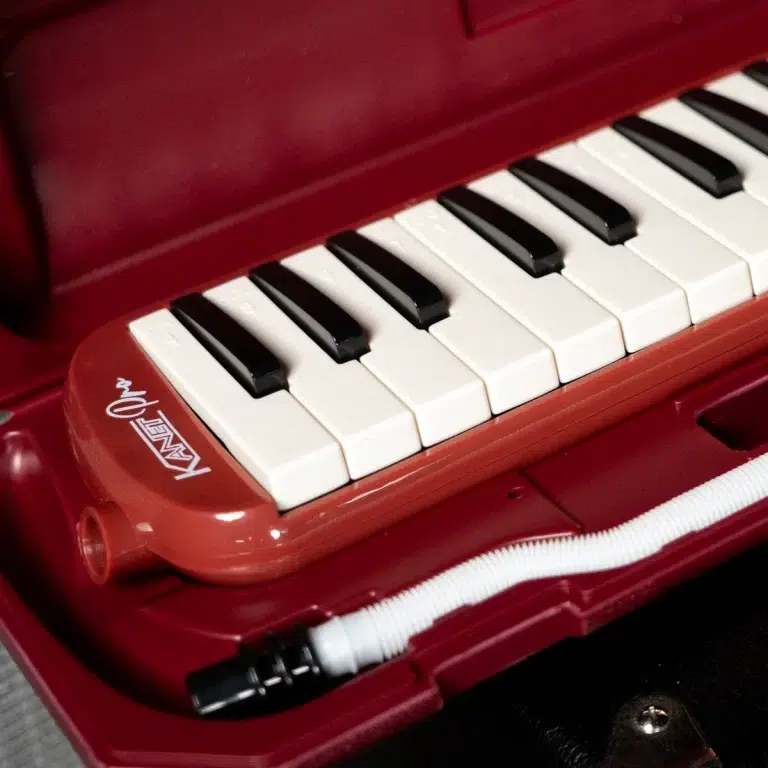 Red portable toy keyboard close-up showing white and black keys and a coiled cord. ขายราคาพิเศษ