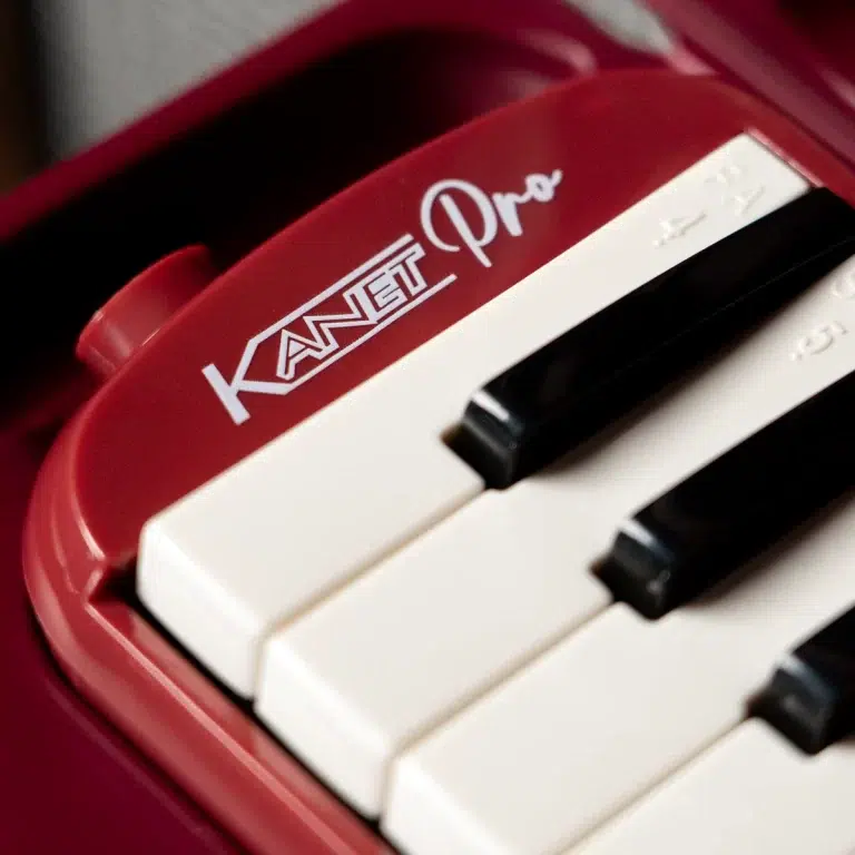 Close-up of a red toy keyboard showing white and black keys with the text 'KANGET Pro' on the surface (macro shot). ขายราคาพิเศษ