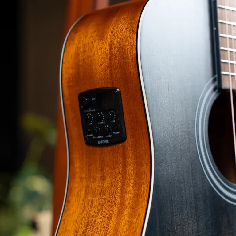 Close-up of an acoustic-electric guitar showing warm wood grain and a built-in control panel on the side ขายราคาพิเศษ