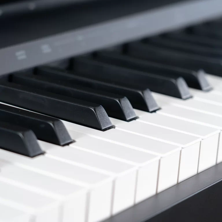 Close-up of black and white piano keys viewed from above, showing a few black keys and white keys in the foreground and background. ขายราคาพิเศษ
