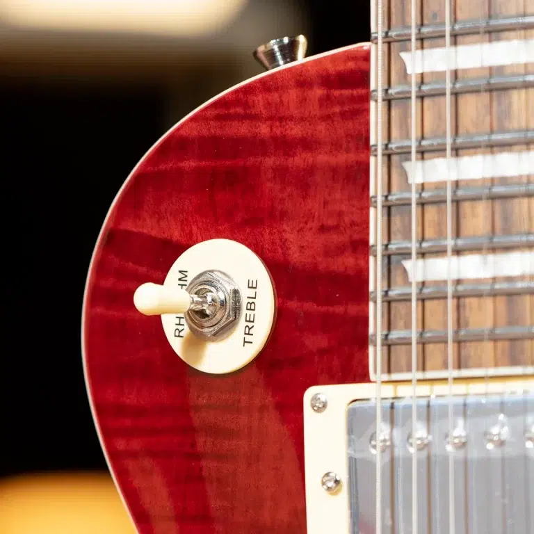 Close-up of a red electric guitar body featuring a cream toggle switch and strings along the neck. ขายราคาพิเศษ