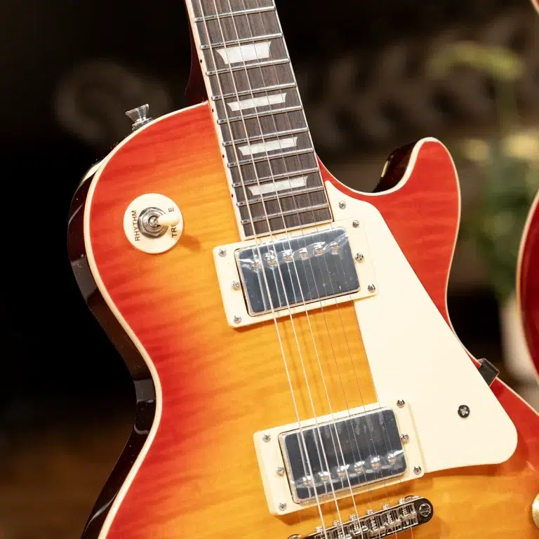 Sunburst electric guitar close-up showing dual humbucker pickups and white pickguard behind the neck area with strings visible in frame. ขายราคาพิเศษ