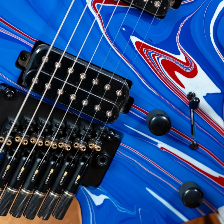 Close-up of a blue electric guitar showing a black pickup, tremolo bridge, and metal strings. ขายราคาพิเศษ