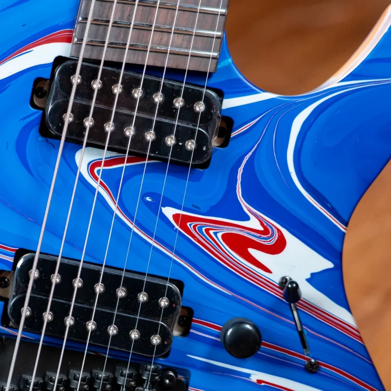 Close-up of a blue electric guitar body with two humbucker pickups, strings, and a swirled red-white-blue design. ขายราคาพิเศษ