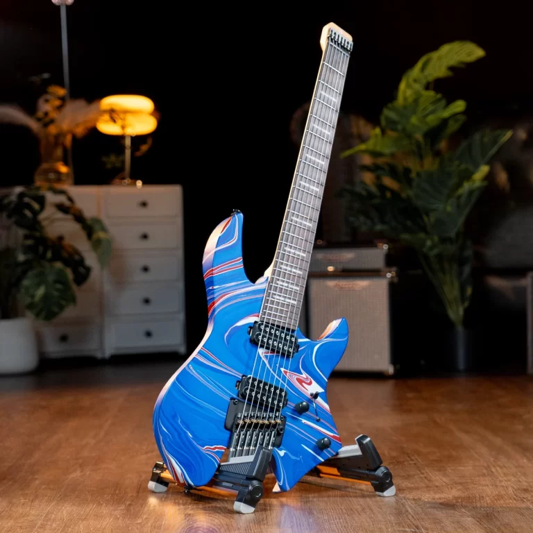 Blue marbled electric guitar on a stand in a dim studio with plants and an amplifier in the background. ขายราคาพิเศษ
