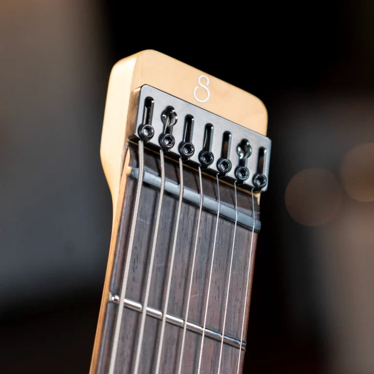 Close-up of a guitar headstock with six tuning pegs and strings over the fretboard. ขายราคาพิเศษ