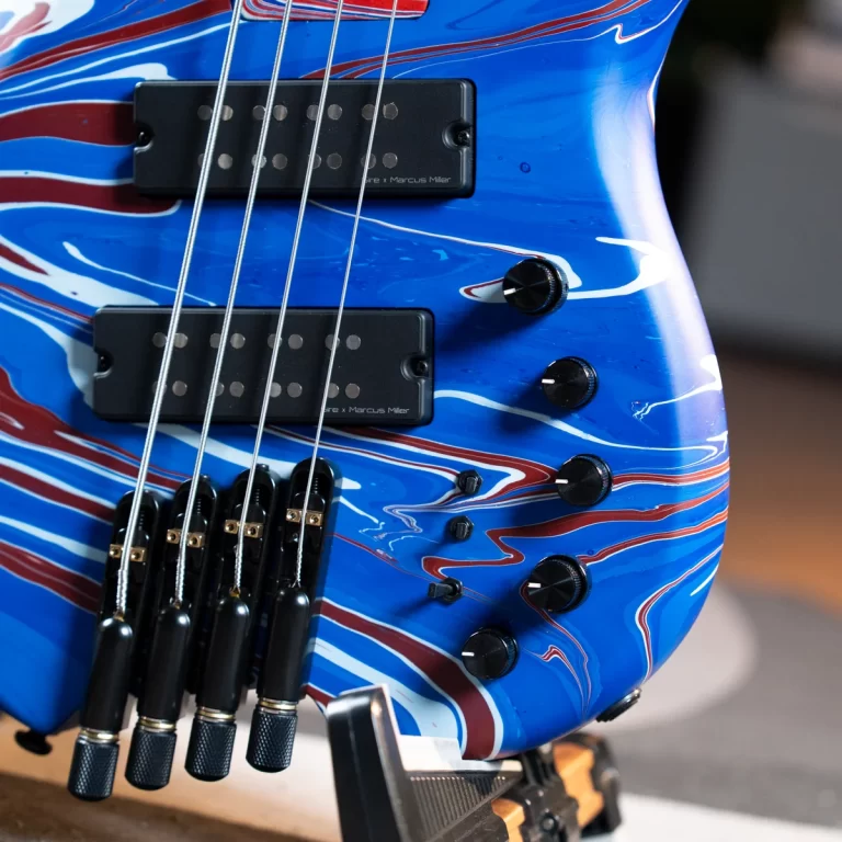 Close-up of a blue swirled electric guitar body with two black humbucker pickups and several control knobs, strings visible. ขายราคาพิเศษ