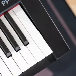 Close-up of a piano keyboard showing black and white keys arranged diagonally on a digital piano. ขายราคาพิเศษ