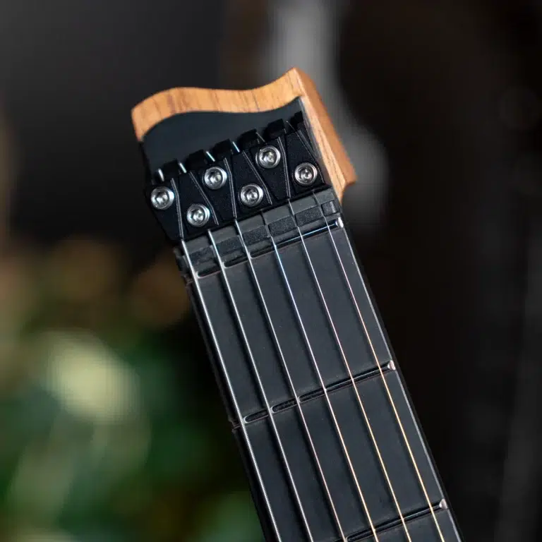 Close-up of a guitar headstock showing six tuning pegs and steel strings against a dark fretboard—electric guitar. ขายราคาพิเศษ