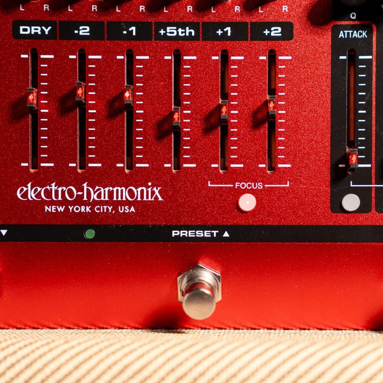 Close-up of a red Electro-Harmonix guitar effects pedal front panel with seven vertical sliders and a focused knob on a glittery finish. ขายราคาพิเศษ