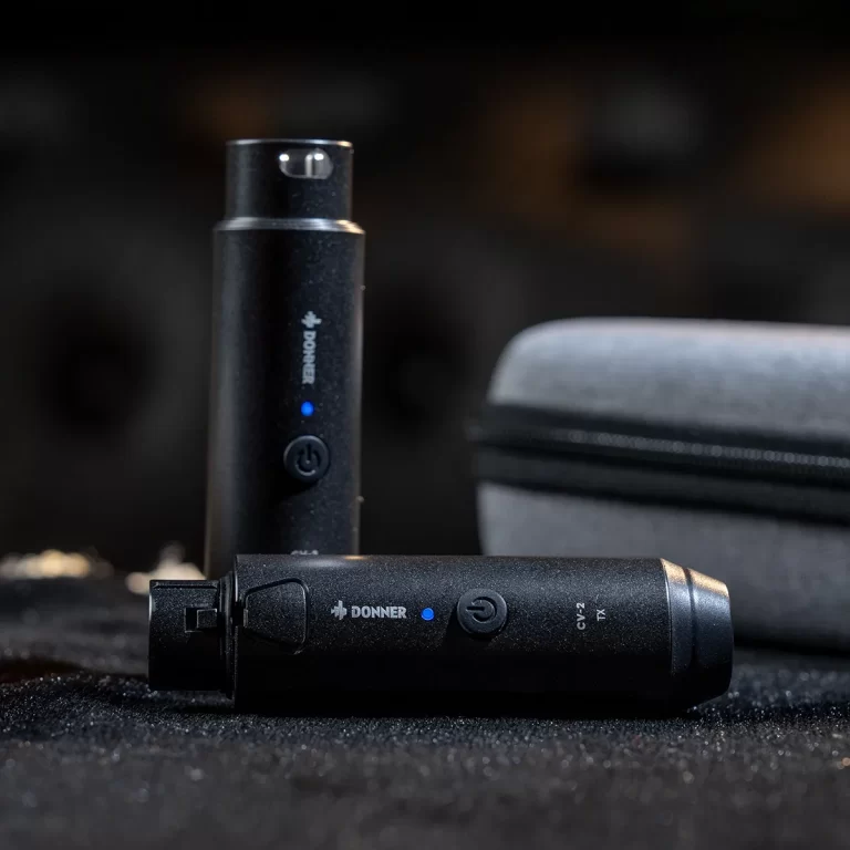 Two black Donner vape pens with blue LED indicators on a dark surface, one upright behind the other. ขายราคาพิเศษ