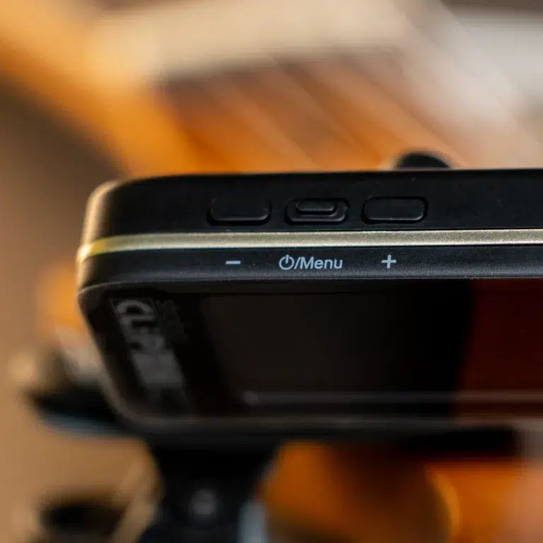 Close-up of a digital camera's top edge with three buttons and a visible Menu label next to a power symbol and plus/minus controls. ขายราคาพิเศษ