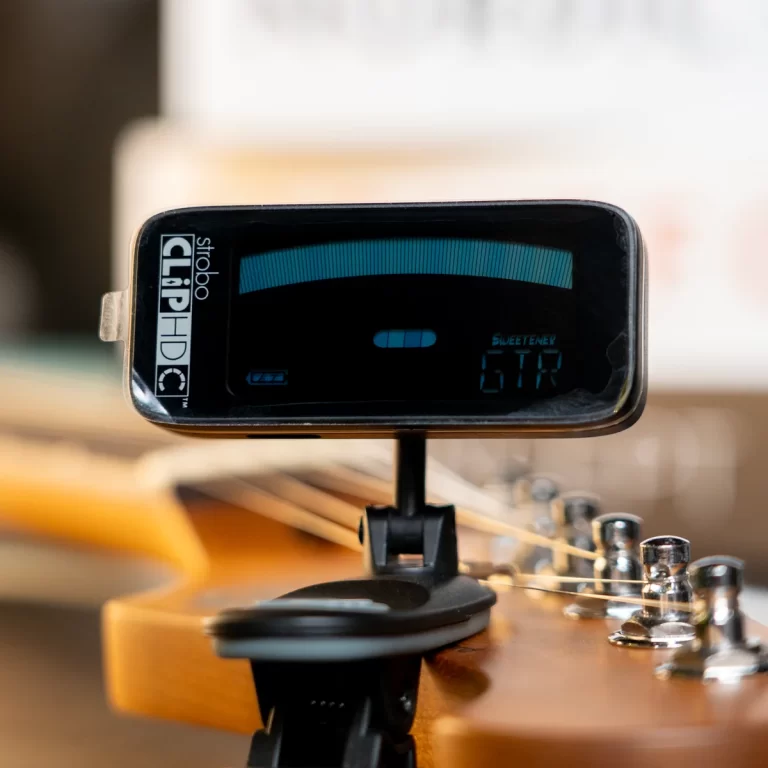 Clip-on guitar tuner mounted on the headstock, displaying a blue arc tuning meter and pitch readout. ขายราคาพิเศษ