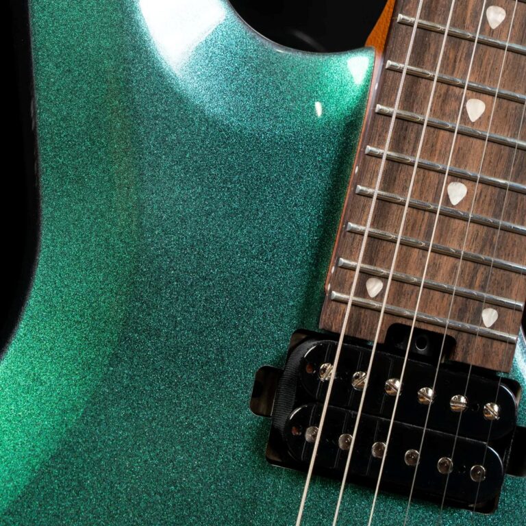 Close-up of a glittery emerald green electric guitar body with a wooden fretboard, strings, and a black humbucker pickup near the bridge. ขายราคาพิเศษ