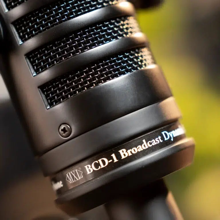 Close-up of a black broadcast microphone with a mesh grille and the label 'BCD-1 Broadcast Dyn' on the base area. ขายราคาพิเศษ