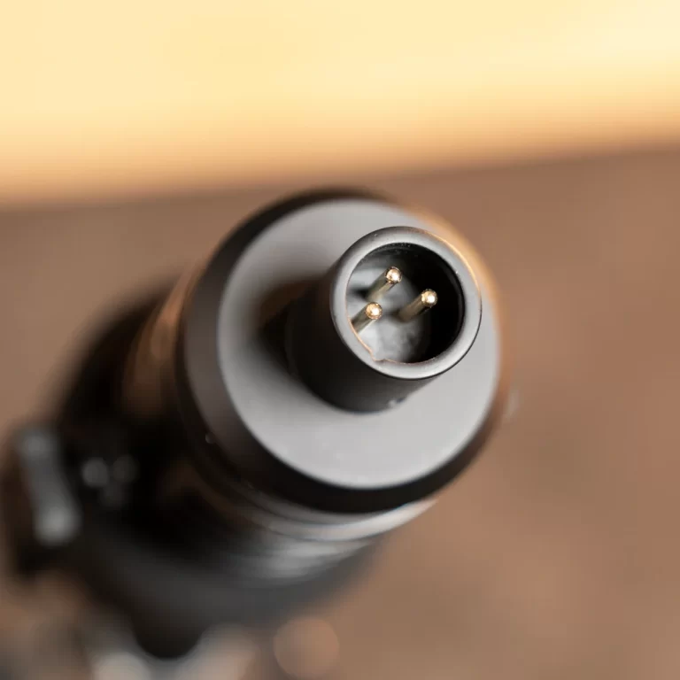 Close-up of a three-pin circular electrical plug viewed from above. ขายราคาพิเศษ