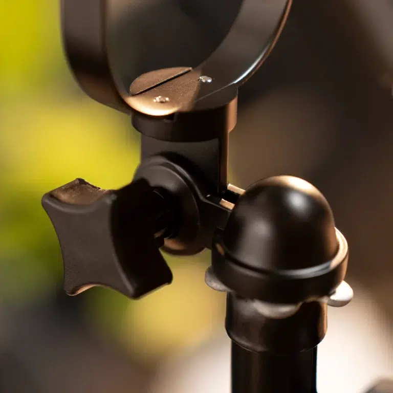 Close-up of a black camera tripod head with knobs and a circular mounting plate ขายราคาพิเศษ