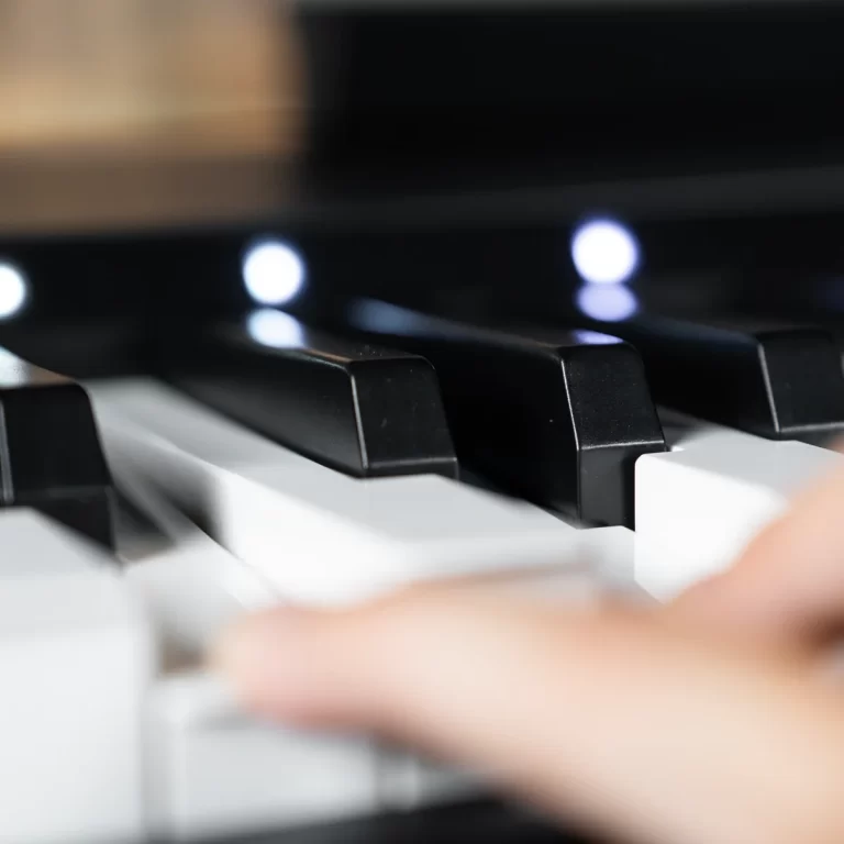 Close-up of a hand playing black and white piano keys, focused on the keys with a blurred hand in motion. ขายราคาพิเศษ
