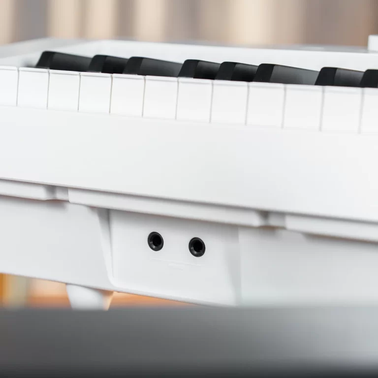 Close-up of a white digital piano keyboard with two jack ports visible on the side. ขายราคาพิเศษ
