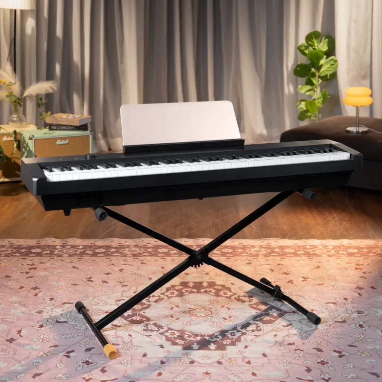 Electronic keyboard on a foldable X‑stand in a cozy living room with rug, plants, and vintage amps in the background. ขายราคาพิเศษ