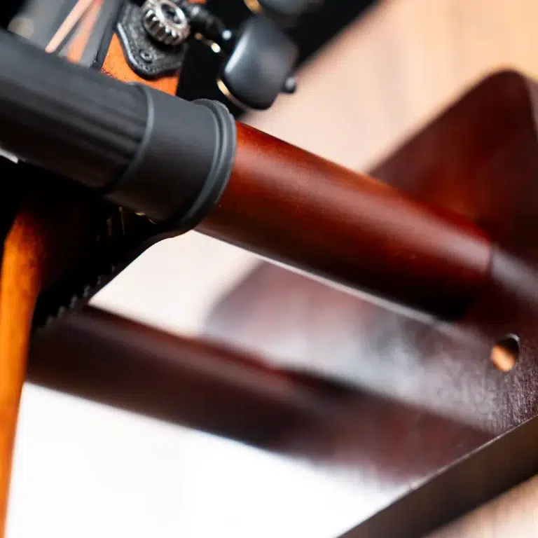 Close-up of a wooden rifle stock with a black scope mount and metal hardware. ขายราคาพิเศษ