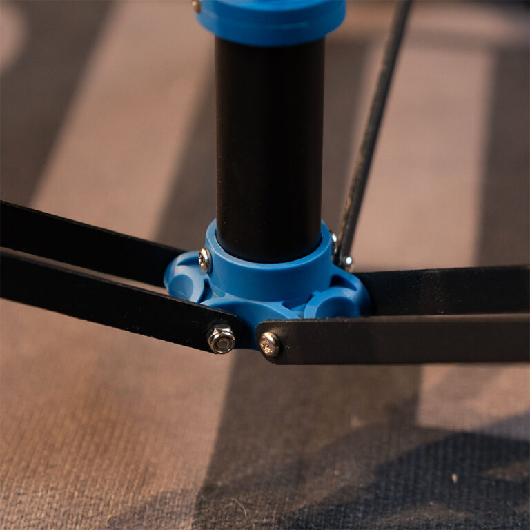 Close-up of a drone propeller hub with blue plastic connector and four black blades attached to a central pole. ขายราคาพิเศษ