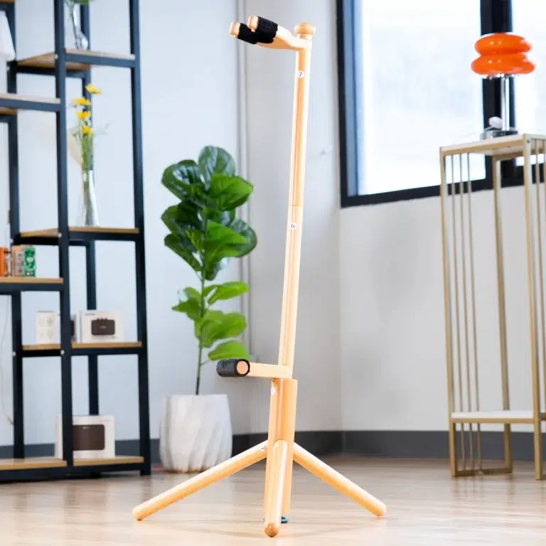 Wooden, height-adjustable walking aid with foam grips on a tripod base in a bright showroom. ขายราคาพิเศษ