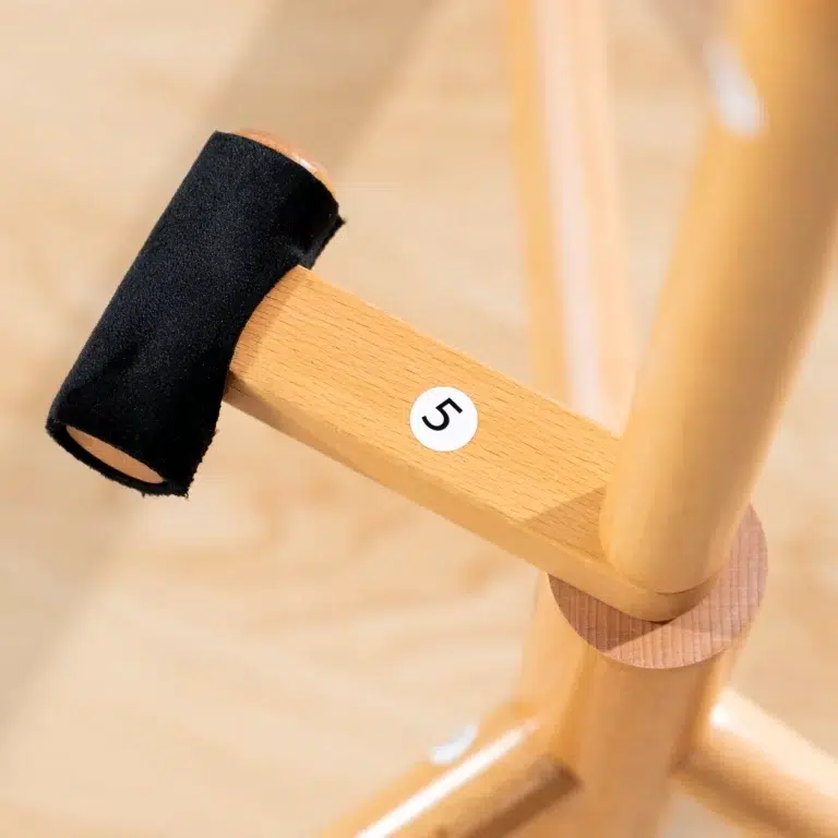 Close-up of a small wooden mallet with a black head resting on a wooden stand, carrying a white sticker labeled '5'. ขายราคาพิเศษ