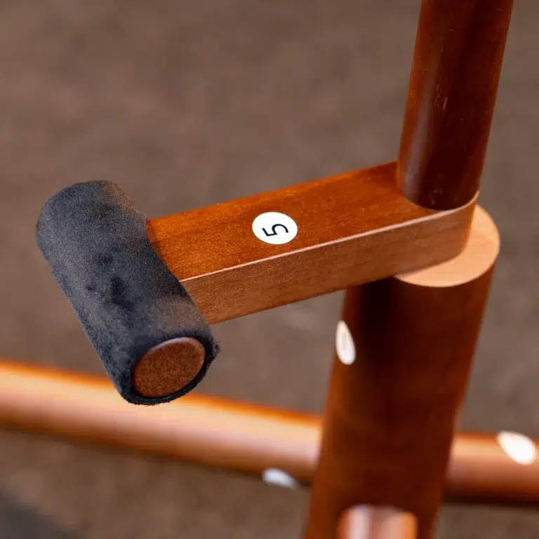 Close-up of a wooden chair arm with a black foam cushion and a white circular sticker labeled '5'. ขายราคาพิเศษ