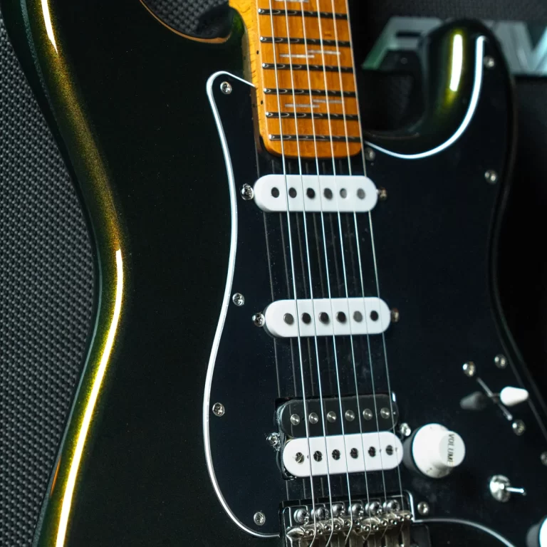 Close-up of a black electric guitar showing a maple neck, white pickups, and chrome hardware along the dark body edge. ขายราคาพิเศษ