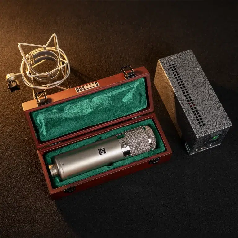 Condenser microphone in a wooden case with green lining, shock mount, and a separate power supply on a dark surface. ขายราคาพิเศษ