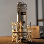 Professional studio microphone mounted in a metal shock mount on a recording desk, ready for vocal recording. ลดราคาพิเศษ