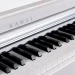Close-up of a white piano keyboard with black keys in focus and the Kawai logo on the fallboard ขายราคาพิเศษ