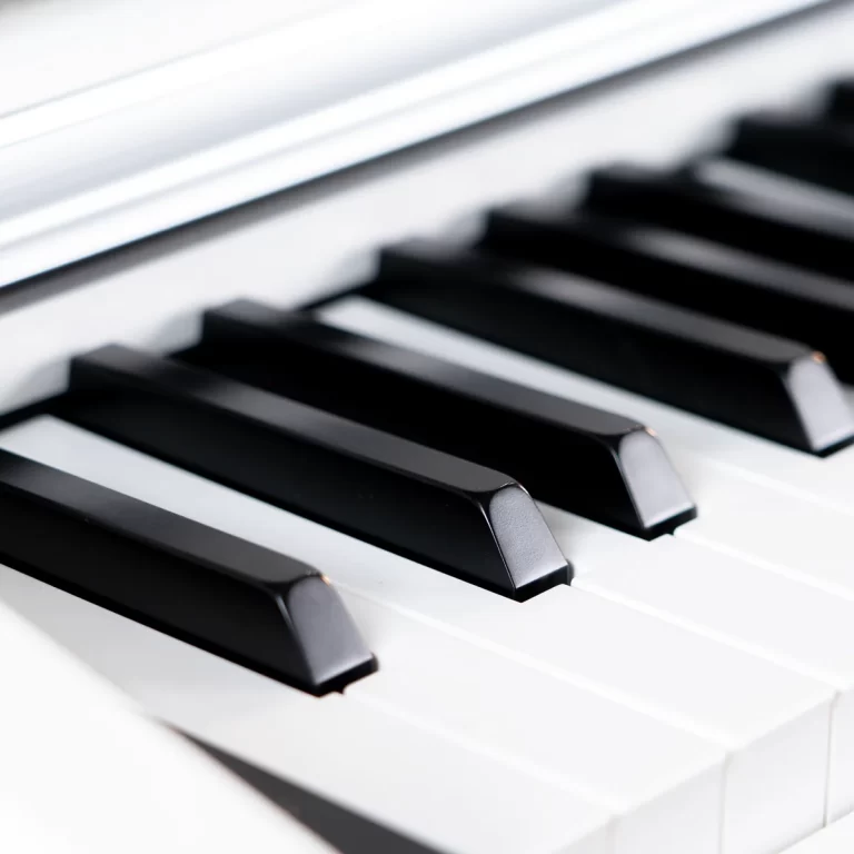 Close-up of a piano keyboard showing glossy black keys on white keys, angled perspective. ขายราคาพิเศษ