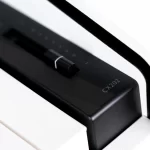 Close-up of a black keyboard switch on a white piano, model CX202 visible on the housing. ขายราคาพิเศษ