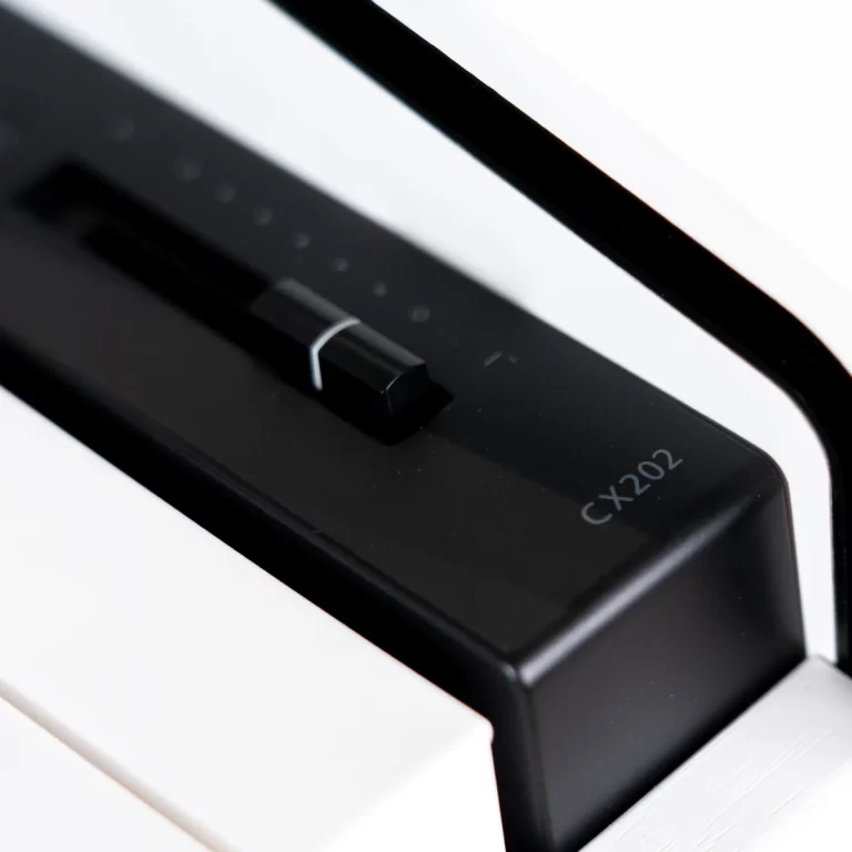 Close-up of a black keyboard switch on a white piano, model CX202 visible on the housing. ขายราคาพิเศษ
