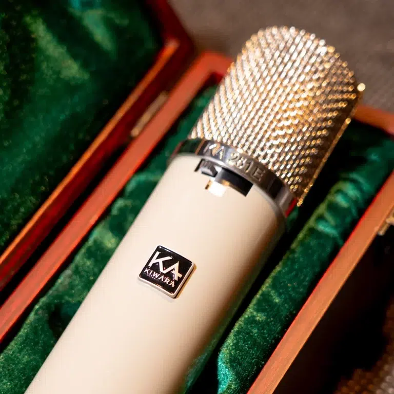 Close-up of a studio microphone with a textured metal grille in a green-lined wooden case. ขายราคาพิเศษ